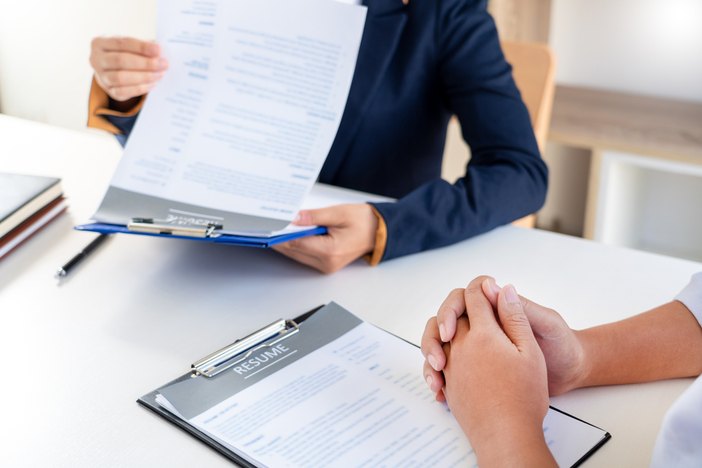 Job applicant sits at a desk during a resume review interview