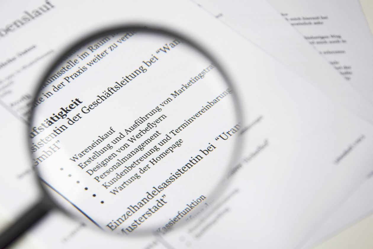 Magnifying glass over a printed CV document