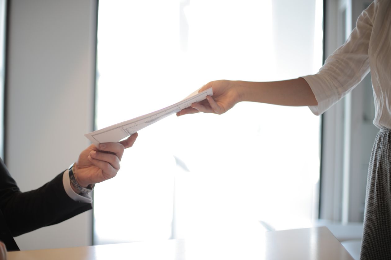 Job applicant handing a printed resume to an employer